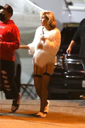 Hollywood, CA  - *EXCLUSIVE*  - Miley Cyrus puts on a very sexy display in fishnet stockings and a furry coat as she is spotted briefly on Wednesday afternoon heading to shoot a project at the Hollywood Palladium. Miley was seen walking to the set in comfy hotel style slides, her hair freshly curled for the shoot.Pictured: Miley CyrusBACKGRID USA 11 NOVEMBER 2021 USA: +1 310 798 9111 / usasales@backgrid.comUK: +44 208 344 2007 / uksales@backgrid.com*UK Clients - Pictures Containing ChildrenPlease Pixelate Face Prior To Publication*
