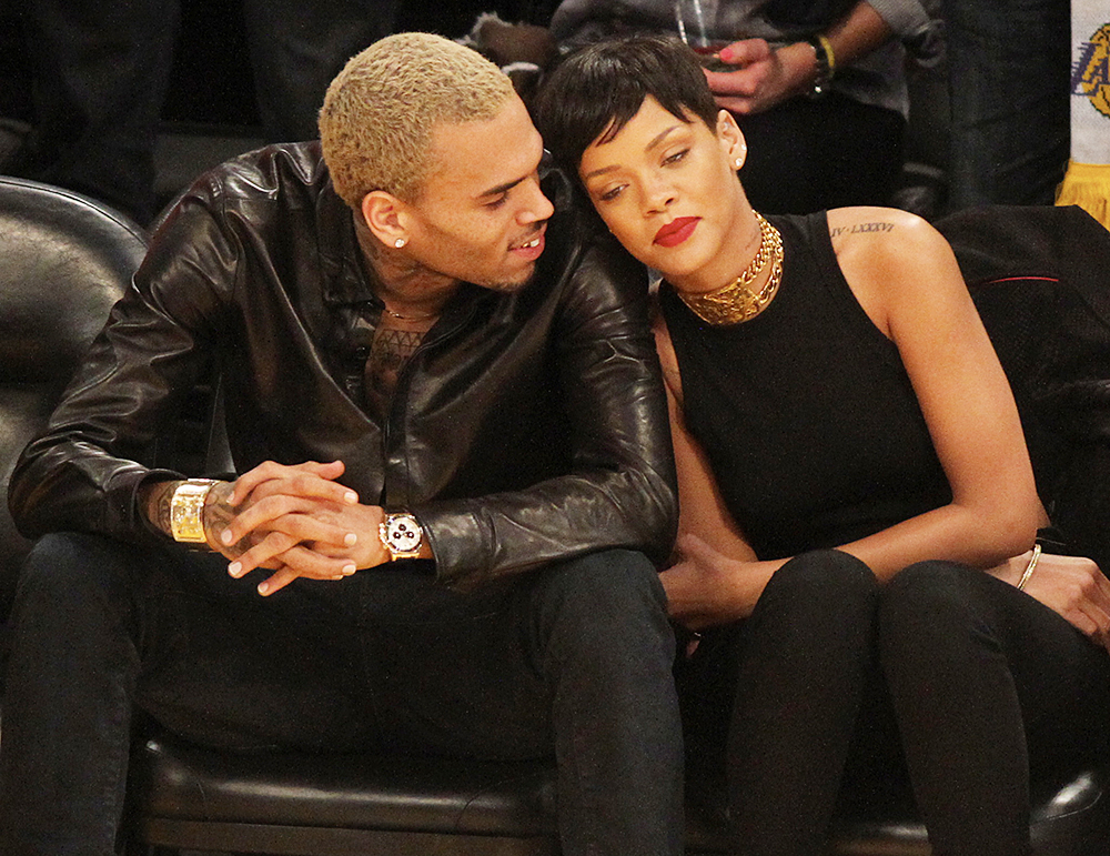 Chris Brown and Rihanna laugh and snuggle as they make  their first public appearance together since their very public break up as they attend the Los Angeles Lakers Vs The New York Knicks Basketball Game