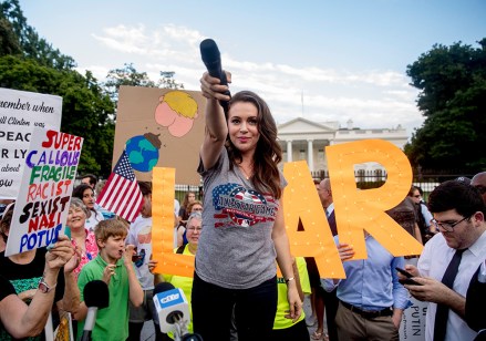 Actress Alyssa Milano holds out her microphone as she starts a chat while speaking at a protest outside the White House, in Washington. This is the second day in a row the group has held a protest following President Donald Trump's meetings with Russian President Vladimir PutinTrump, Washington, USA - 17 Jul 2018
