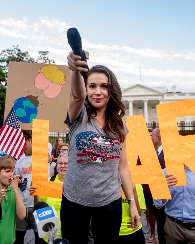 Actress Alyssa Milano holds out her microphone as she starts a chat while speaking at a protest outside the White House, in Washington. This is the second day in a row the group has held a protest following President Donald Trump's meetings with Russian President Vladimir PutinTrump, Washington, USA - 17 Jul 2018