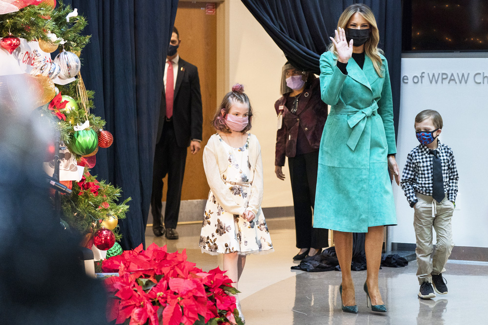 First lady Melania Trump arrives to read a Christmas story with Sofia Martinez, 8, left, and Riley Whitney, 6, both children who are patients at Children's National Hospital, Tuesday, Dec. 15, 2020, during an annual event in Washington. Due to pandemic concerns there were two children in the room and the reading was broadcast to children in the rest of the hospital. (AP Photo/Jacquelyn Martin)