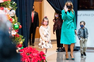 First lady Melania Trump arrives to read a Christmas story with Sofia Martinez, 8, left, and Riley Whitney, 6, both children who are patients at Children's National Hospital, Tuesday, Dec. 15, 2020, during an annual event in Washington. Due to pandemic concerns there were two children in the room and the reading was broadcast to children in the rest of the hospital. (AP Photo/Jacquelyn Martin)