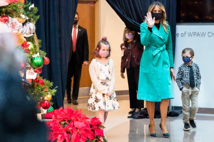 First lady Melania Trump arrives to read a Christmas story with Sofia Martinez, 8, left, and Riley Whitney, 6, both children who are patients at Children's National Hospital, Tuesday, Dec. 15, 2020, during an annual event in Washington. Due to pandemic concerns there were two children in the room and the reading was broadcast to children in the rest of the hospital. (AP Photo/Jacquelyn Martin)