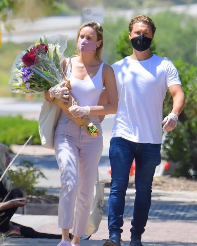 EXCLUSIVE: Brie Larson out with her boyfriend Elijah Allan-Blitz to buy some pretty flowers. The pair were seen stepping out to a local farmer's market where they purchased flowers and a couple of other items. They wore face masks and gloves as they kept a safe distance from other people at the market. Brie was once again in a pair of pink slippers however this time they were a fuzzy pair. 26 Apr 2020 Pictured: Brie larson and Elijah Allan-Blitz. Photo credit: Snorlax / MEGA TheMegaAgency.com +1 888 505 6342 (Mega Agency TagID: MEGA653512_002.jpg) [Photo via Mega Agency]