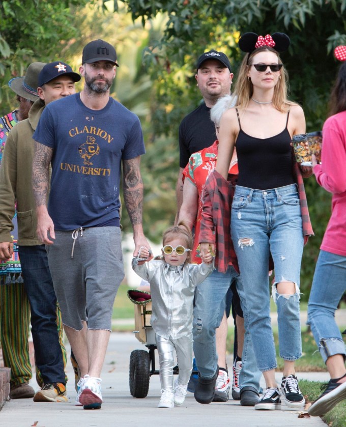Adam Levine & Behati Prinsloo holding hands with their daughter