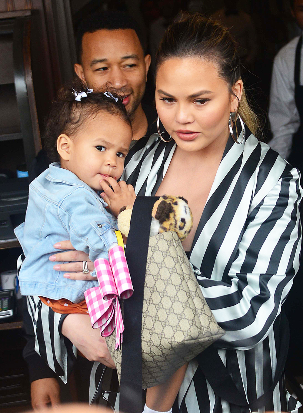 John Legend and Chrissy Teigen get mobbed by the paparazzi as they and their daughter leave Il Pistaio Restaurant in Beverly Hills, Ca