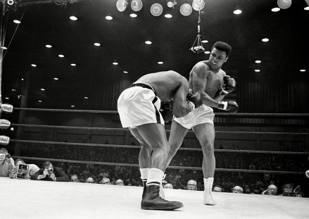 Muhammad Ali, or Cassius Clay as he was known at the time, whips a right to the head of ducking champ Sonny Liston during the first round of the heavyweight title fight in Miami Beach, Fla
Boxing Champion Muhammad Ali, Miami Beach, USA