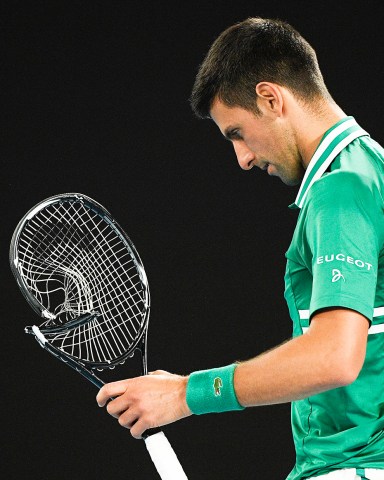 Serbia's Novak Djokovic walks to replace his smashed racket during his quarterfinal match against Germany's Alexander Zverev at the Australian Open tennis championship in Melbourne, Australia, Tuesday, Feb. 16, 2021.(AP Photo/Andy Brownbill)