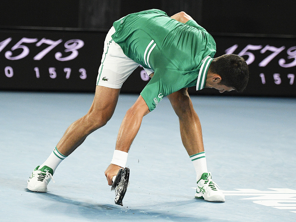 Serbia's Novak Djokovic smashes his racket during his quarterfinal match against Germany's Alexander Zverev at the Australian Open tennis championship in Melbourne, Australia, Tuesday, Feb. 16, 2021.(AP Photo/Andy Brownbill)