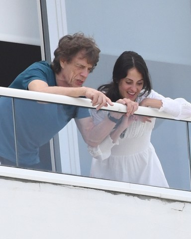 Rolling Stones frontman Mick Jagger and girlfriend Melanie Hamrick enjoy the view from their Miami Beach hotel balcony. The group was forced to reschedule their concert in the city for a second time as the arrival of hurricane Dorian draws near. 29 Aug 2019 Pictured: Mick Jagger; The Rolling Stones; Melanie Hamrick. Photo credit: MEGA TheMegaAgency.com +1 888 505 6342 (Mega Agency TagID: MEGA491268_002.jpg) [Photo via Mega Agency]