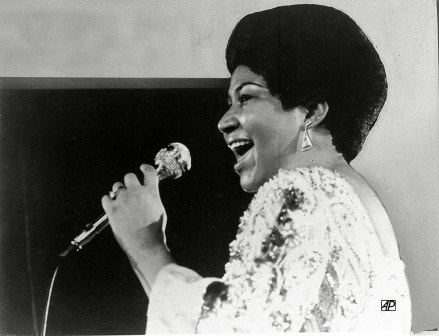 ARETHA FRANKLIN Vocalist Aretha Franklin warbles a few notes into microphone in photo
ARETHA FRANKLIN, USA