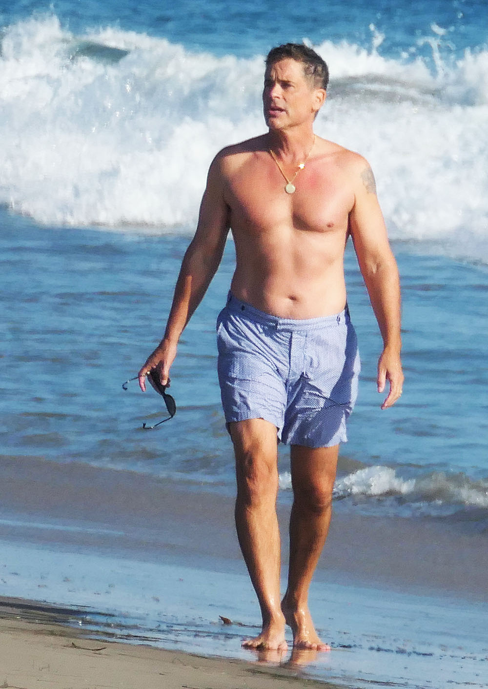 EXCLUSIVE: Rob Lowe takes his shirt off for a walk on the beach in Santa Barbara Sunday with friends.