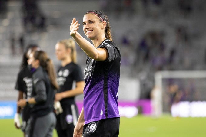 Alex Morgan waves to fans at game