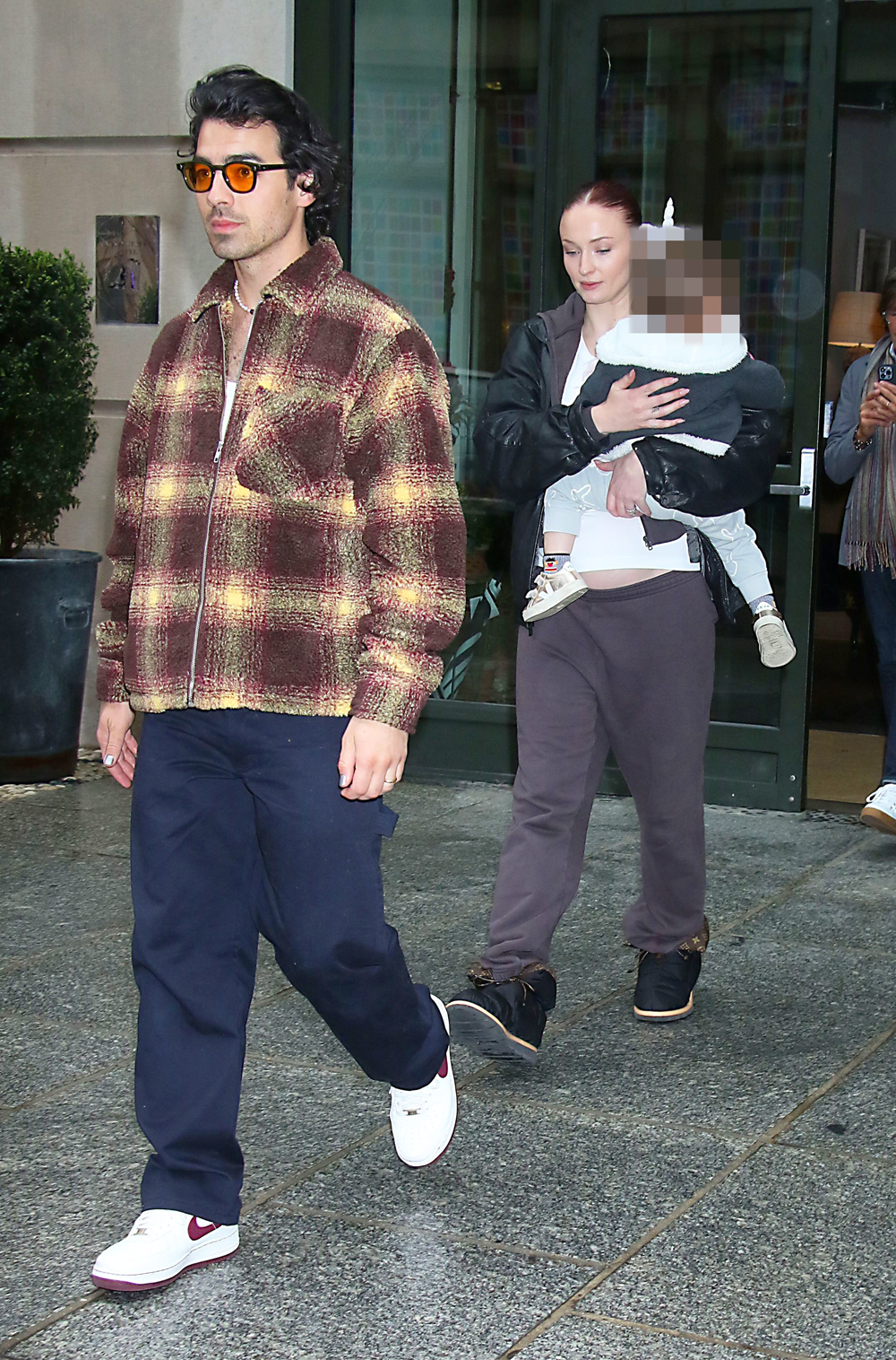 Sophie Turner shows off her growing baby bump in a crop top and leggings  while out