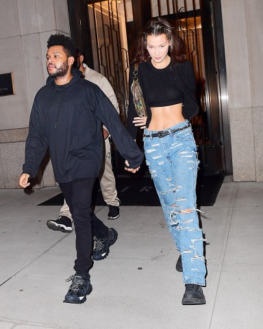 Bella Hadid and The Weeknd were spotted leaving her Manhattan NYC apartment on Friday night. The couple headed to dinner after reuniting following a busy Fashion Month for the Runway model. She flaunted her to-die-for abs in a crop top as they walked to their SUV. They were all smiles but they seemed to be playing coy about a large Diamond ring on Bella's hand. She hid one of her hands behind her back, while concealing an ENORMOUS diamond on the hand she had intertwined in the singer's. He covered the ring with 2 hands as they got into the car, just giving a quick glance at it.Pictured: Ref: SPL5028849 280918 NON-EXCLUSIVEPicture by: 247PAPS.TV / SplashNews.comSplash News and PicturesLos Angeles: 310-821-2666New York: 212-619-2666London: 0207 644 7656Milan: +39 02 4399 8577Sydney: +61 02 9240 7700photodesk@splashnews.comWorld Rights, No Portugal Rights