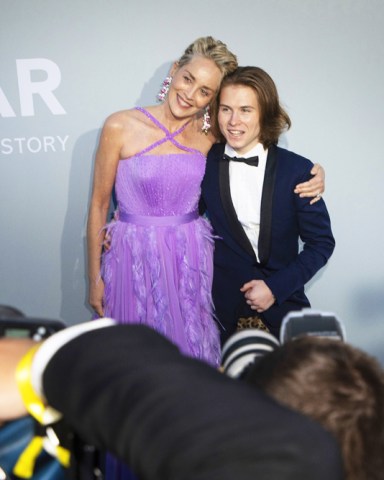 Sharon Stone, left, and Roan Joseph Bronstein pose for photographers upon arrival at the amfAR Cinema Against AIDS benefit the during the 74th Cannes international film festival, Cap d'Antibes, southern France 2021 amfAR Arrivals, Cannes, France - 16 Jul 2021