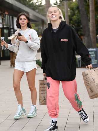 EXCLUSIVE: JoJo Siwa and TikTok model Savannah Demers flirt with each other while shopping for food together at Erewhon in Los Angeles Wednesday. This is the first time the Youtube superstar, 19, has been photographed since breaking up with her ex-girlfriend Avery Cyrus last month. She went casual in a hoodie and sweatpants with Converse high tops for the outing, while her new love showed off her long legs in shorts and sneakers. The duo were all smiles, giggling at the cash register before walking to the car looking happy and relaxed. 18 Jan 2023 Pictured: JoJo Siwa flirts with her new TikTok model girlfriend Savannah Demers while on lunch a date. Photo credit: GP / MEGA TheMegaAgency.com +1 888 505 6342 (Mega Agency TagID: MEGA934102_003.jpg) [Photo via Mega Agency]