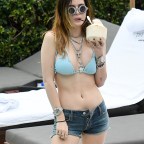 Actress Bella Thorne and wears a blue string bikini as she relaxes by the pool with sister Dani in Miami