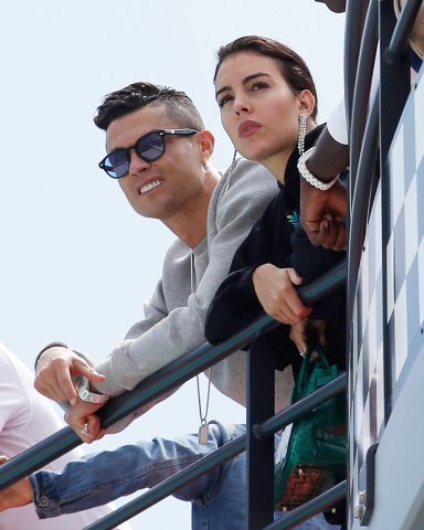 Cristiano Ronaldo, left, is flanked by his partner Georgina Rodriguez as they watch the second practice session at the Monaco racetrack, in Monaco, . The Formula one race will be held on Sunday F1 GP Auto Racing, Monaco, Monaco - 23 May 2019
