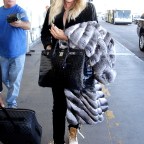 Pregnant Khloe Kardashian covers her baby bump with a fur coat as she jets to Cleveland to spend New Year's Eve with beau Tristan Thompson