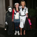 Kelly Ripa, dressed up as an astronaut, poses with her kids Joaquin and Lola outside her apartment on Halloween
