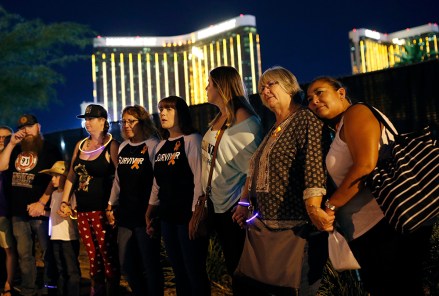 Survivors of a mass shooting form a human chain around the shuttered site of a country music festival on the first anniversary, in Las Vegas. As people were linking arms and holding hands Monday night near the concert site, officials and several hundred others across town listened to bagpipes and the names of the 58 victims being read aloudShooting, Las Vegas, USA - 01 Oct 2018