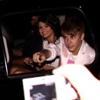 Justin Bieber and Selena Gomez point to fans in their SUV, when leaving MMVA's in Toronto, Canada
