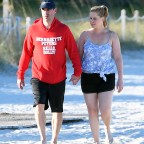 EXCLUSIVE: Newlyweds Amy Schumer and Chris Fischer laugh and hold hands as they take a walk along the beach in Miami