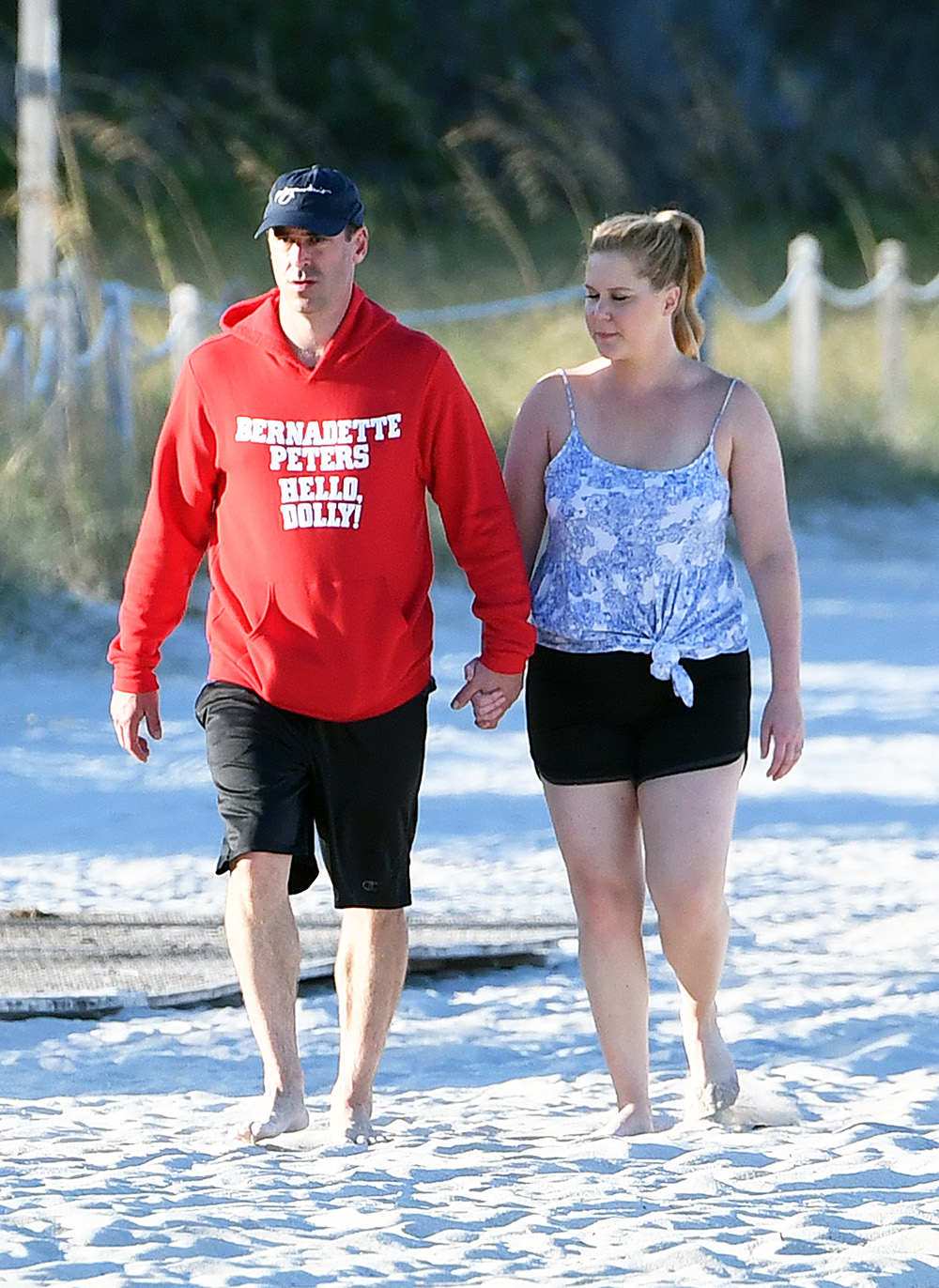 EXCLUSIVE: Newlyweds Amy Schumer and Chris Fischer laugh and hold hands as they take a walk along the beach in Miami