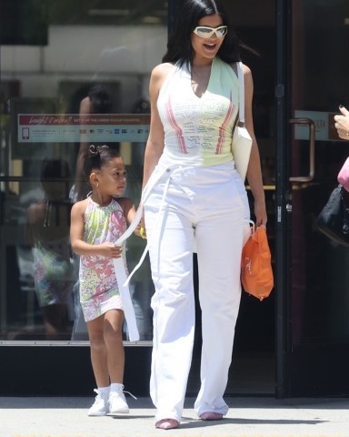 Calabasas, CA  - *EXCLUSIVE*  - Kylie Jenner makes a public appearance alongside her 4-year-old daughter Stormi. Kylie, dressed in white pants and a white/yellow top with a daring neckline, keeps a smile on her face as she holds Stormi by the hand during their exit.  Pictured: Kylie Jenner, Stormi Webster   BACKGRID USA 8 JUNE 2022   USA: +1 310 798 9111 / usasales@backgrid.com  UK: +44 208 344 2007 / uksales@backgrid.com  *UK Clients - Pictures Containing Children Please Pixelate Face Prior To Publication*