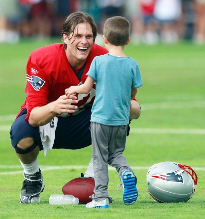 Tom Brady Том Брэди из New England Patriots приветствует своего сына Джека на поле после футбольного тренировочного лагеря NFL, Фоксборо, Mass Patriots Camp Football, Фоксборо, США