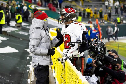 Tampa Bay Buccaneers quarterback Tom Brady, 12, celebrates with his son Jack in the stands after the NFL NFC Championship football game against the Green Bay Packers on Sunday, Jan. 24, 2021 in Green Bay, Wisconsin. . Packers, 31-26, advance to Super Bowl LV.  (Ryan Kang via AP)