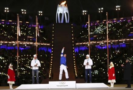 Alexander Bolshunov, silver, at left, of the team from Russia, and Andrey Larkov, of the team from Russia, bronze, at right, applaud as Iivo Niskanen, of Finland, gold, celebrates during the medals ceremony for the men's 50k cross-country skiing at the closing ceremony of the 2018 Winter Olympics
Olympics Closing Ceremony, Pyeongchang, South Korea - 25 Feb 2018
