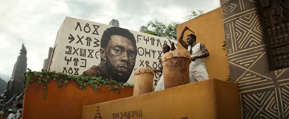BLACK PANTHER: WAKANDA FOREVER, (aka BLACK PANTHER II), Chadwick Boseman (on mural), © Marvel / © Walt Disney Studios Motion Pictures / Courtesy Everett Collection