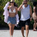 Bikini clad Amelia Hamlin happily applies sunscreen to boyfriend Scott Disick as they relax on the beach on Valentine's Day in Miami
