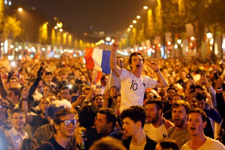 People celebrate on the Champs Elysees avenue after the semifinal match between France and Belgium at the 2018 soccer World Cup, in Paris. France advanced to the World Cup final for the first time since 2006 with a 1-0 win over Belgium on TuesdayWCup Soccer, Paris, France - 10 Jul 2018