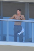 Skjortefri Mark Wahlberg lytter til sin iPod i Miami