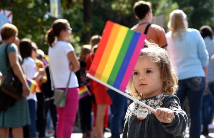 Seorang anak Montenegro memegang bendera pelangi selama pawai Kebanggaan Lesbian, Gay, Biseksual dan Transgender (LGBT) di Podgorica, Montenegro, 23 September 2017. Ratusan aktivis dan pendukung gay berbaris di jalan-jalan Podgorica menyerukan lebih banyak hak.  Hak LGBT adalah isu kontroversial di Montenegro dan di tempat lain di wilayah Balkan, di mana masyarakat dianggap lebih konservatif.  Kebanggaan LGBT pertama di Montenegro pada Juli 2013 berakhir dengan polisi melepaskan tembakan peringatan ke udara untuk membubarkan nasionalis anti-gay yang melempari batu dan memukuli peserta.  Reli Gay Pride di Podgorica, Montenegro - 23 Sep 2017