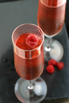 coupes of pink champagne with raspberry