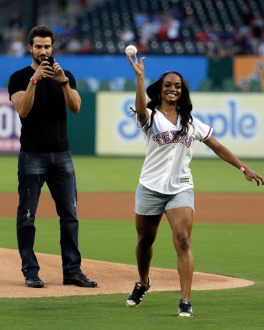 Rachel Lindsay, Bryan Abasolo Rachel Lindsay, a Dallas attorney and contestant of "The Bachelorette," throws out the ceremonial first pitch as her fiance, Bryan Abasolo, rear, records the moment before a baseball game between the Houston Astros and the Texas Rangers, in Arlington, Texas
Astros Rangers Baseball, Arlington, USA - 11 Aug 2017