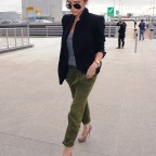 Victoria Beckham arriving at Heathrow Airport on a flight from Los Angeles.  The Spice Girl singer wore olive coloured trousers, a black blazer, grey t-shirt and sunglasses. A gold watch completed her look.