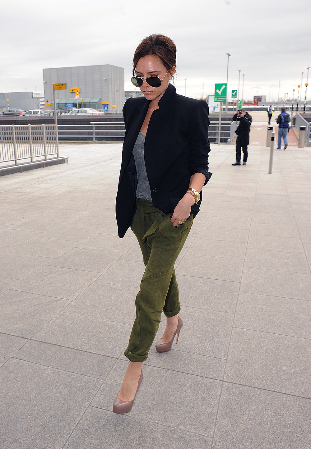 Victoria Beckham arriving at Heathrow Airport on a flight from Los Angeles.  The Spice Girl singer wore olive coloured trousers, a black blazer, grey t-shirt and sunglasses. A gold watch completed her look.