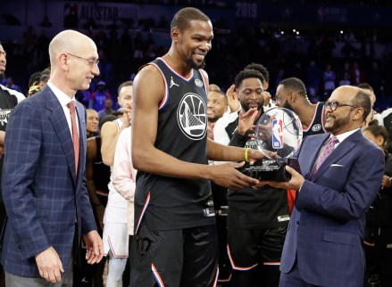 Team LeBron's Kevin Durant, of the Golden State Warriors receives the MVP trophy after the NBA All-Star basketball game as NBA commissioner Adam Silver, left, looks on Sunday, Feb. 17, 2019, in Charlotte, N.C. The Team LeBron won 178-164. (AP Photo/Chuck Burton)