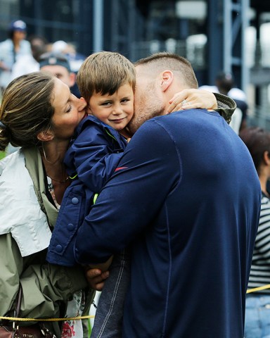 New England Patriots quarterback Tom Brady and his wife Gisele Bundchen with their son Benjamin Brady after a joint workout with the Tampa Bay Buccaneers at NFL football training camp, in Foxborough, Mass., Tuesday, Aug. 13, 2013. (AP Photo/Charles Krupa)