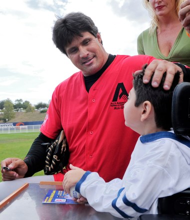 Jose Canseco, Dominic Bumo Former Major League Baseball player Jose Canseco pats Dominic Bumo, who has ALS, at Steve Garvey's Celebrity Softball Game for ALS Research (also known as Lou Gehrig's disease), in Malibu, Calif
Steve Garvey Summer Classic, Malibu, USA