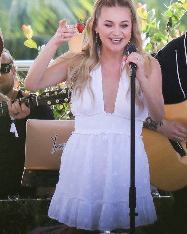 Miami Beach, FL  - American singer-songwriter Kelsea Ballerini was invited to sing for Aerie fans during spring break by The Pool at Strawberry Moon at The Goodtime Hotel in Miami Beach. During the performance, the country singer cools off with a cocktail after finishing her song. The blonde singer sang 3 songs, and on the last one, she confessed that she "just learned" the song.  Pictured: Kelsea Ballerini  BACKGRID USA 16 MARCH 2022   USA: +1 310 798 9111 / usasales@backgrid.com  UK: +44 208 344 2007 / uksales@backgrid.com  *UK Clients - Pictures Containing Children Please Pixelate Face Prior To Publication*