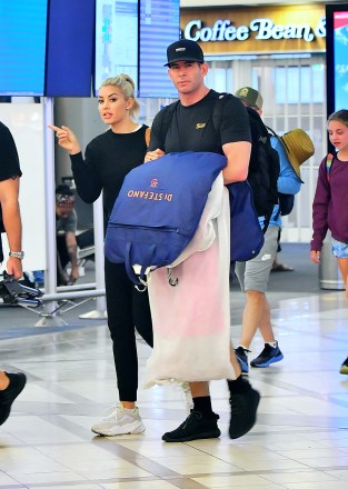 EXCLUSIVE: Tarek El Moussa and new girlfriend Heather Rae Young hold each other as they are spotted arriving into LAX airport in Los Angeles, CA. 16 Aug 2019 Pictured: Tarek El Moussa, Heather Rae Young. Photo credit: Marksman / MEGA TheMegaAgency.com +1 888 505 6342 (Mega Agency TagID: MEGA483504_005.jpg) [Photo via Mega Agency]