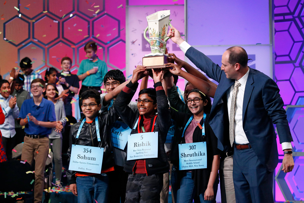 E.W. Scripps CEO Adam Symson, right, presents a trophy to the eight co-champions of the Scripps National Spelling Bee, in Oxon Hill, Md. The spelling bee ended in unprecedented 8-way championship tie after organizers ran out of challenging wordsSpelling Bee, Oxon Hill, USA - 31 May 2019