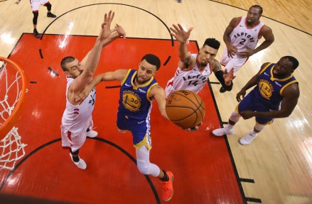 Golden State Warriors' Stephen Curry (30) drives to the basket between Toronto Raptors' Marc Gasol, left, and Danny Green (14) during Game 1 of basketball’s NBA Finals, Thursday, May 30, 2019, in Toronto. (Gregory Shamus/Pool Photo via AP)