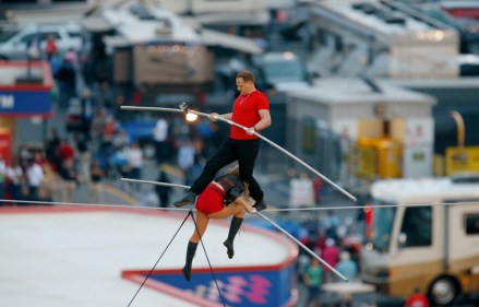Nik Wallenda steps over his sister Lijana Wallenda as they perform on a tightrope before the NASCAR Sprint Cup Series auto race at Charlotte Motor Speedway in Concord, N.C., Saturday, Oct. 12, 2013. (AP Photo/Chris Keane)